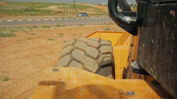 Tractor con una excavadora moviendo el suelo en un sitio de construcción — Vídeo de stock