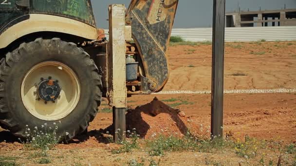 Трактор з буровим пристроєм на будівельному майданчику — стокове відео