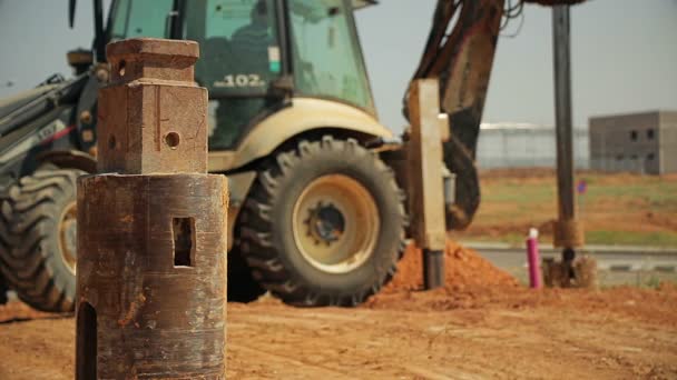 Трактор с буровым устройством на строительной площадке — стоковое видео