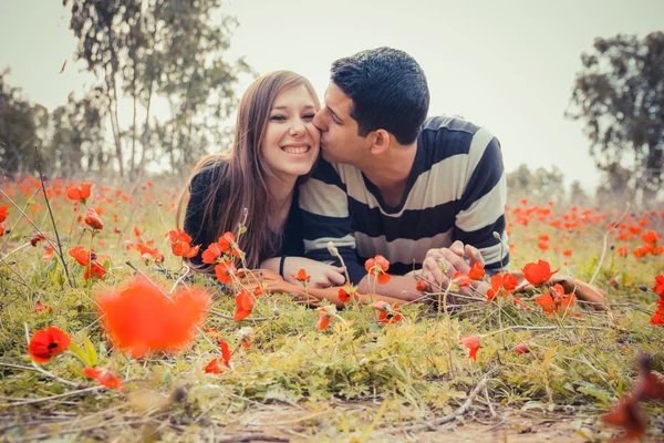 Man kussen vrouw en ze heeft een toothy glimlach terwijl ze leggen o — Stockfoto