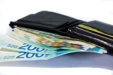 Bir yığın İsrail şekeli para açık siyah deri cüzdanda..