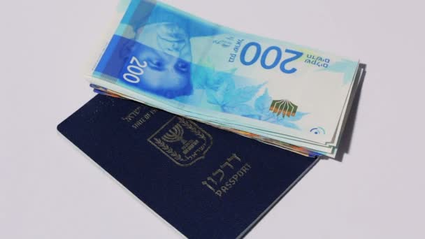 Girando billetes israelíes de 200 shekel y pasaporte israelí - vista superior lazo sin fisuras — Vídeos de Stock