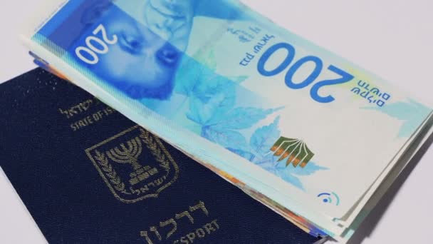 Fatture monetarie rotanti israeliane da 200 shekel e passaporto israeliano - loop senza soluzione di continuità vista dall'alto — Video Stock