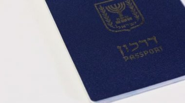 Beyaz arka plan üzerinde dönen İsrail pasaportu