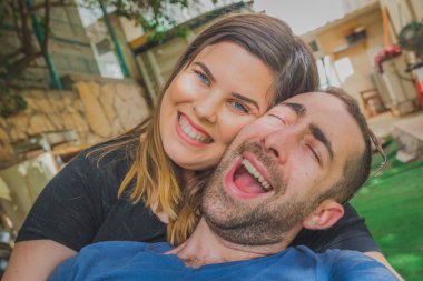 Genç çift birlikte arka bahçesinde zevk. Onlar gülüyor, gülüyor ve komik surat