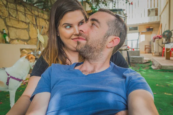 Junges Paar genießt zusammen im Hinterhof. sie lächeln, lachen und machen zusammen lustige Gesichter — Stockfoto
