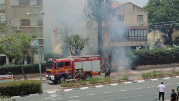 Árbol de ciprés ardiendo en llamas ardientes en el patio trasero de una casa como resultado de cortocircuitos. Bomberos luchan para prevenir más damag — Vídeos de Stock