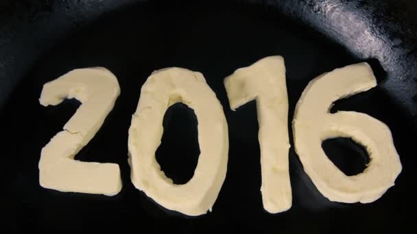 Mantequilla en forma de número 2016 fusión en la sartén caliente - Vista superior de cerca — Vídeos de Stock