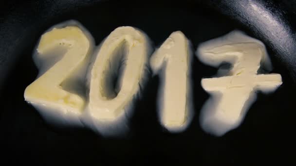 Масло у формі числа 2017 тане на гарячій сковороді крупним планом — стокове відео