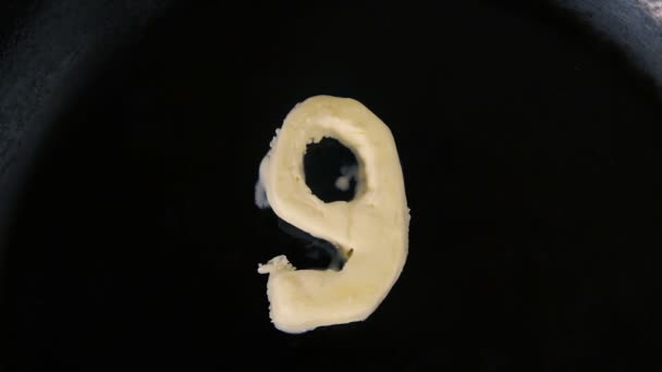 Масло в форме 9 расплава на горячей сковороде - Закрыть вид сверху — стоковое видео