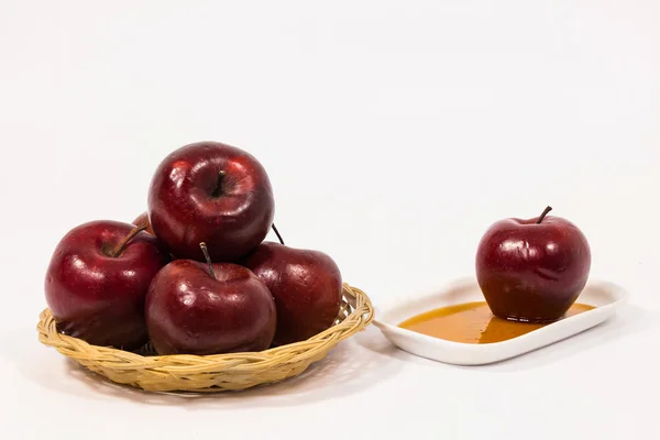 Montón de manzanas rojas y manzana roja en plato blanco con miel — Foto de Stock
