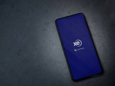 Lod, Israel - 8 Temmuz 2020: XE Para Birimi uygulama ekranı koyu mermer taşlı arka planda siyah bir cep telefonunun logosu var. Üst görünüm düzlüğü kopyalama alanı ile yatıyordu.