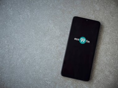Lod, Israel - 8 Temmuz 2020: eco999music uygulama ekranı seramik taş zemin üzerinde siyah bir cep telefonunun logosu var. Üst görünüm düzlüğü kopyalama alanı ile yatıyordu.
