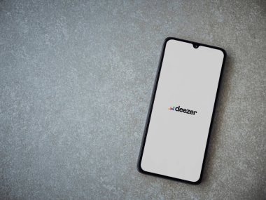 Lod, Israel - 8 Temmuz 2020: Deezer Music Player uygulaması seramik taş zemin üzerinde siyah bir cep telefonunun logosu olan fırlatma ekranı. Üst görünüm düzlüğü kopyalama alanı ile yatıyordu.