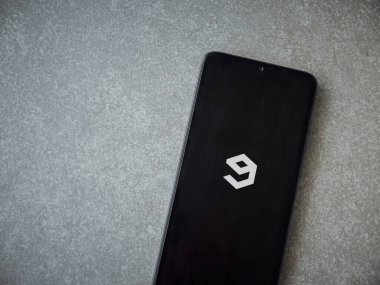 Lod, Israel - 8 Temmuz 2020: 9GAG uygulama ekranıyla seramik taş zemin üzerinde siyah bir cep telefonu görüntüsü. Üst görünüm düzlüğü kopyalama alanı ile yatıyordu.