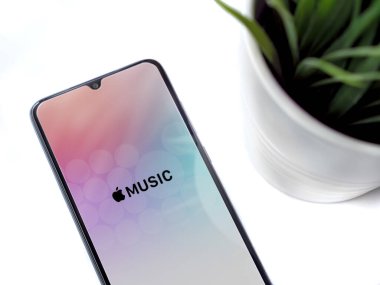 Lod, Israel - 8 Temmuz 2020: Apple Music uygulamalı siyah cep telefonlu, beyaz arka planda logosu olan modern minimalist ofis çalışma alanı. Üst görünüm yatağını kapat.