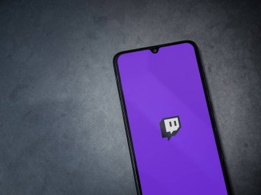Lod, Israel - 8 Temmuz 2020: Koyu mermer taşlı arka planda siyah bir cep telefonunun logosu olan Twitch uygulaması fırlatma ekranı. Üst görünüm düzlüğü kopyalama alanı ile yatıyordu.