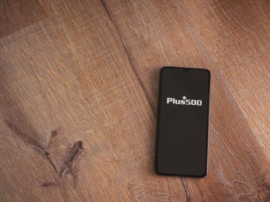 Lod, Israel - 8 Temmuz 2020: Ahşap arka planda siyah bir cep telefonunun logosu olan artı 500 uygulama başlatma ekranı. Üst görünüm düzlüğü kopyalama alanı ile yatıyordu.