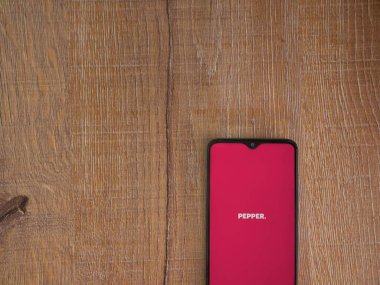 Lod, Israel - 8 Temmuz 2020: Ahşap arka planda siyah bir cep telefonunun logosu olan biber uygulaması fırlatma ekranı. Üst görünüm düzlüğü kopyalama alanı ile yatıyordu.