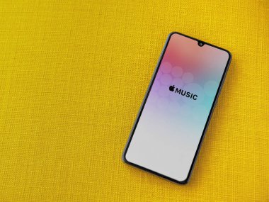 Lod, Israel - 8 Temmuz 2020: Apple Music uygulama ekranı üzerinde sarı kumaş arka planda siyah bir cep telefonunun logosu var. Üst görünüm düzlüğü kopyalama alanı ile yatıyordu.