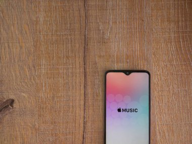 Lod, Israel - 8 Temmuz 2020: Apple Music uygulama ekranı üzerinde siyah bir cep telefonunun logosu olan ahşap arka planda. Üst görünüm düzlüğü kopyalama alanı ile yatıyordu.