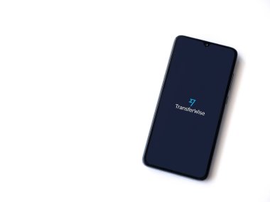 Lod, Israel - 8 Temmuz 2020: Beyaz arkaplanda izole edilmiş siyah bir cep telefonunun logosunda logo bulunan TransferWise uygulaması fırlatma ekranı. Üst görünüm düzlüğü kopyalama alanı ile yatıyordu.
