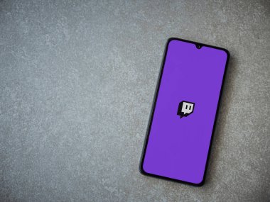 Lod, Israel - 8 Temmuz 2020: Seramik taş zemin üzerinde siyah bir cep telefonunun logosu olan Twitch uygulaması fırlatma ekranı. Üst görünüm düzlüğü kopyalama alanı ile yatıyordu.