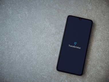 Lod, Israel - 8 Temmuz 2020: Seramik taş zemin üzerinde siyah bir cep telefonunun logosu olan TransferWise uygulama başlatma ekranı. Üst görünüm düzlüğü kopyalama alanı ile yatıyordu.