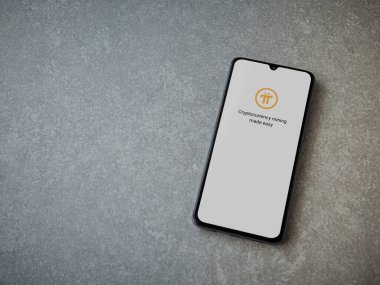 Lod, Israel - 8 Temmuz 2020: Pi Ağı uygulama ekranı seramik taş zemin üzerinde siyah bir cep telefonunun logosu var. Üst görünüm düzlüğü kopyalama alanı ile yatıyordu.