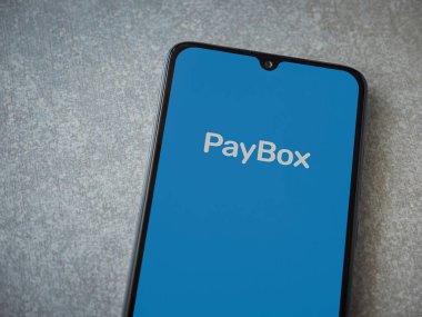 Lod, Israel - 8 Temmuz 2020: PayBox uygulama ekranı seramik taş zemin üzerinde siyah bir cep telefonunun logosu var. Üst görünüm düzlüğü kopyalama alanı ile yatıyordu.