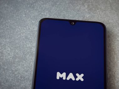 Lod, Israel - 8 Temmuz 2020: Seramik taş zemin üzerinde siyah bir cep telefonunun logosu olan Max uygulama fırlatma ekranı. Üst görünüm düzlüğü kopyalama alanı ile yatıyordu.