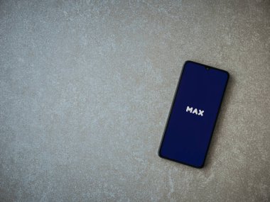 Lod, Israel - 8 Temmuz 2020: Seramik taş zemin üzerinde siyah bir cep telefonunun logosu olan Max uygulama fırlatma ekranı. Üst görünüm düzlüğü kopyalama alanı ile yatıyordu.