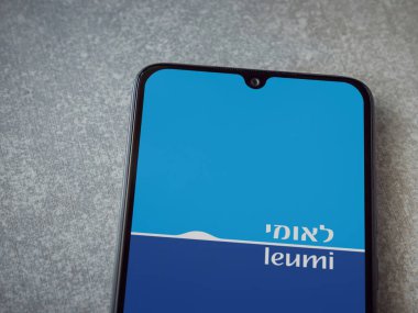 Lod, Israel - 8 Temmuz 2020: Bank Leumi uygulaması seramik taştan arka planda siyah bir cep telefonunun logosu İbranice metin ile çalıştırma ekranı. Üst görünüm düzlüğü kopyalama alanı ile yatıyordu.