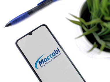 Lod, Israel - 8 Temmuz 2020: Beyaz arka planda logosu olan siyah cep telefonlu modern minimalist ofis çalışma alanı. Üst görünüm düzlüğü kopyalama alanı ile yatıyordu.