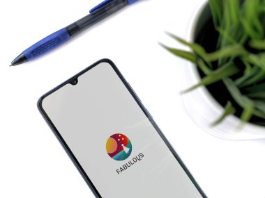 Lod, Israel - 8 Temmuz 2020: Beyaz arka planda logosu olan siyah cep telefonlu modern minimalist ofis çalışma alanı. Üst görünüm düzlüğü kopyalama alanı ile yatıyordu.