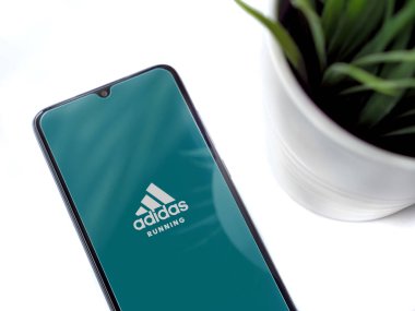 Lod, Israel - 8 Temmuz 2020: Beyaz arka planda logosu olan siyah cep telefonlu modern minimalist ofis çalışma alanı. Üst görünüm düzlüğü kopyalama alanı ile yatıyordu.