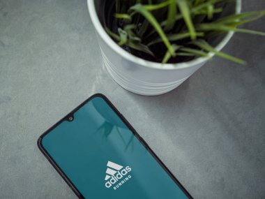 Lod, Israel - 8 Temmuz 2020: Mermer zemin üzerinde logosu olan siyah cep telefonlu modern minimalist ofis çalışma alanı. Üst görünüm düzlüğü kopyalama alanı ile yatıyordu.