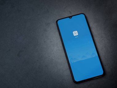 Lod, Israel - 8 Temmuz 2020: Mi Fit uygulama ekranıyla koyu mermer taşlı arka planda siyah bir cep telefonunun logosu görülüyor. Üst görünüm düzlüğü kopyalama alanı ile yatıyordu.