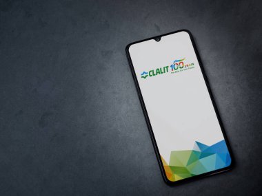 Lod, Israel - 8 Temmuz 2020: Clalit Sağlık Hizmetleri uygulama ekranı koyu mermer taşlı arka planda siyah bir cep telefonunun logosu var. Üst görünüm düzlüğü kopyalama alanı ile yatıyordu.