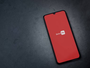 Lod, Israel - 8 Temmuz 2020: BetterMe uygulama ekranı koyu mermer taşlı arka planda siyah bir cep telefonunun logosu var. Üst görünüm düzlüğü kopyalama alanı ile yatıyordu.