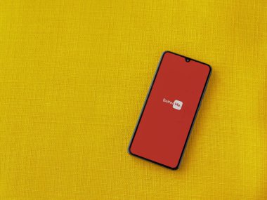 Lod, Israel - 8 Temmuz 2020: BetterMe uygulama ekranı üzerinde sarı kumaş arka planda siyah bir cep telefonunun logosu var. Üst görünüm düzlüğü kopyalama alanı ile yatıyordu.