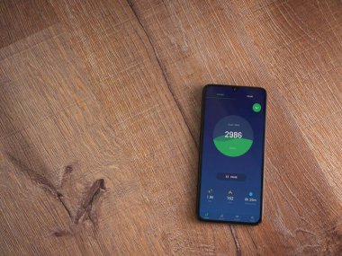 Lod, Israel - 8 Temmuz 2020: Sıçrama Fitness Step Counterapp kalkış ekranı üzerinde siyah bir cep telefonunun logosu olan tahta arka planda. Üst görünüm düzlüğü kopyalama alanı ile yatıyordu.