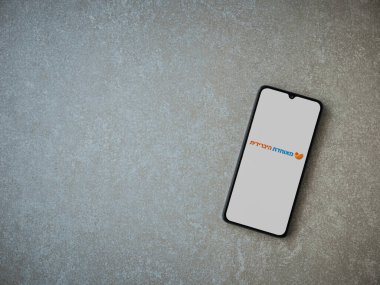 Lod, Israel - 8 Temmuz 2020: Meuhedet Sağlık Hizmetleri uygulaması seramik taş zemin üzerinde siyah bir cep telefonunun logosu İbranice metin ile çalıştırma ekranı. Üst görünüm düzlüğü kopyalama alanı ile yatıyordu.