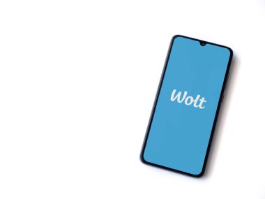 Lod, Israel - 8 Temmuz 2020: Beyaz arka planda izole edilmiş siyah bir cep telefonunun logosu olan Wolt uygulaması fırlatma ekranı. Üst görünüm düzlüğü kopyalama alanı ile yatıyordu.