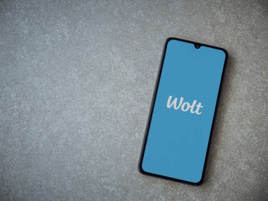 Lod, Israel - 8 Temmuz 2020: Seramik taş zemin üzerinde siyah bir cep telefonunun logosu olan Wolt uygulaması fırlatma ekranı. Üst görünüm düzlüğü kopyalama alanı ile yatıyordu.