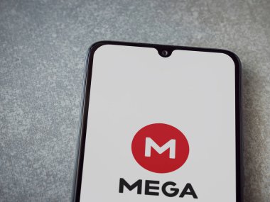 Lod, Israel - 8 Temmuz 2020: MeGA uygulama başlatma ekranı seramik taş zemin üzerinde siyah bir cep telefonunun logosu. Üst görünüm düzlüğü kopyalama alanı ile yatıyordu.
