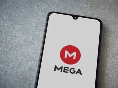 Lod, Israel - 8 Temmuz 2020: MeGA uygulama başlatma ekranı seramik taş zemin üzerinde siyah bir cep telefonunun logosu. Üst görünüm düzlüğü kopyalama alanı ile yatıyordu.
