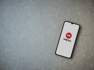 Lod, Israel - 8 Temmuz 2020: MeGA uygulama başlatma ekranı seramik taş zemin üzerinde siyah bir cep telefonunun logosu. Üst görünüm düzlüğü kopyalama alanı ile yatıyordu.