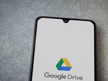 Lod, Israel - 8 Temmuz 2020: Google Drive uygulama ekranı seramik taş zemin üzerinde siyah bir cep telefonunun logosu var. Üst görünüm düzlüğü kopyalama alanı ile yatıyordu.