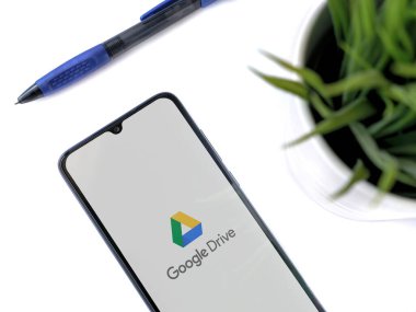 Lod, Israel - 8 Temmuz 2020: Google Drive uygulama ekranlı siyah cep telefonlu modern minimalist ofis çalışma alanı. Üst görünüm düzlüğü kopyalama alanı ile yatıyordu.